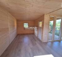 Interior of a wooden room with windows and a floor; Gardens.