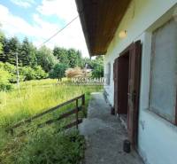 A cottage in Stará Huta surrounded by greenery and forests, with open doors to nature.