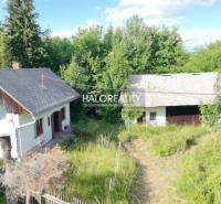 A cottage in Stará Huta surrounded by greenery, wooden fence, spacious yard, natural environment.