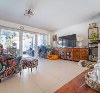 Living room in a family house with colorful armchairs and a large television on a dresser.