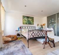 A bedroom in a family house with a bed, carpet, and sliding wardrobe.