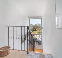 A staircase with a metal railing and a window, a floor with a wooden decor, family house.