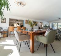 Living room in a family house with a large table, comfortable chairs, and a zebra-patterned armchair.
