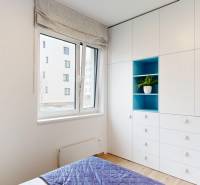 Bright children's room with a built-in wardrobe and a floor-to-ceiling window with a wooden decor.