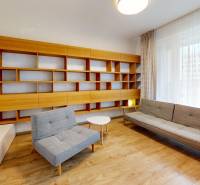 Living room in a 4-room apartment with shelves, a couch, and a wooden decor floor.