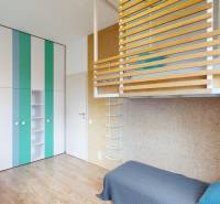 A room with colorful shelves, a bunk bed, and a floor with a wooden decor.