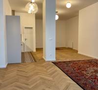Living room in a two-room apartment with a wooden decor floor and oriental rugs.