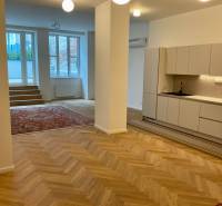 A kitchen corner with a wooden decor floor and stairs in a 2-room apartment.