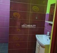 A colorful bathroom in a family house with a sink and tiles in contrasting colors.