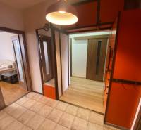 Hallway of a 3-room apartment with tiles, wardrobe closets, and passage to the bedroom.