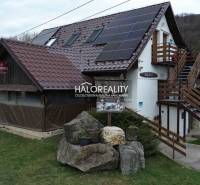 The exterior of the restaurant in Hnúšťa with wooden elements and solar panels on the roof.
