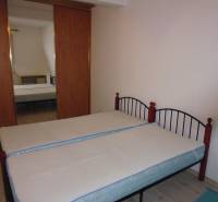 Double bed, wardrobe with mirror, and wooden decor flooring in a 2-room apartment.