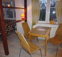 Dining area with a table and wicker chairs, floor with wooden decor.
