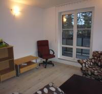 Living room in a two-room apartment with a wooden decor floor and comfortable seating.