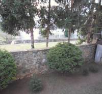 A garden with conifers and a stone wall near a 2-room apartment on Veselá Street in Prešov.