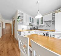A bright kitchen in a 3-room apartment with a wooden table and a floor with a wooden decor.