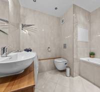 A bathroom with a bathtub, sink, and toilet in a 3-room apartment.