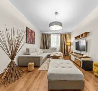 Living room in a 3-room apartment with a wooden decor floor and comfortable seating.