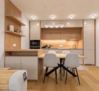 A kitchen in a 2-room apartment with a dining table and a floor with a wooden decor.