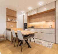 A kitchen in a 2-room apartment with modern furniture and a wooden decor floor.