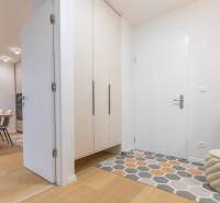 Entrance hallway with wood-patterned flooring and modern furniture to a 2-room apartment.