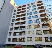 A ten-story building with balconies, parked cars in the city of Poprad.