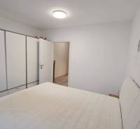 Bedroom in a family house with a white wardrobe and a bed.