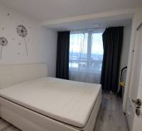 Bedroom in a family house with white furniture and walls with dandelion motifs.