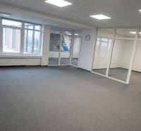 Open office space with glass partitions and carpet.