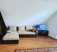 Living room with a sofa in a three-room apartment and a floor with a wooden decor.