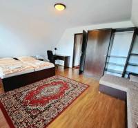 Bedroom with a double bed, sofa, table, and floor with wood decor.