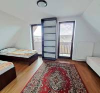 A bedroom in a 3-room apartment with two beds, a carpet, and a wooden decor floor.