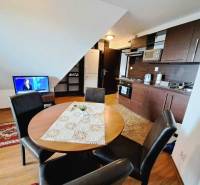 A kitchen in a 3-room apartment with a wooden decor and a dining table.