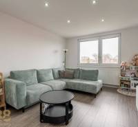 Living room with a corner sofa and a wooden decor floor in a 4-room apartment.