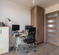 A workspace in a 4-room apartment with a wooden decor floor and office equipment.