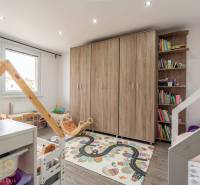 Children's room in a 4-room apartment with a decorative carpet and books.