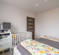 The children's room in the 4-room apartment contains a bed, a crib, and a changing table.