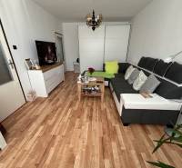 Living room in a three-room apartment with a large sofa and a floor with a wooden decor.