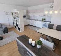 A kitchen with a sofa and a wooden decor floor in a 2-room apartment.