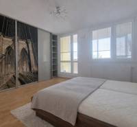 A bright bedroom with a large wardrobe and a wooden decor floor in a 2-room apartment.