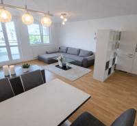 Living room with kitchen, sofa set, and wooden decor flooring in a 2-room apartment.