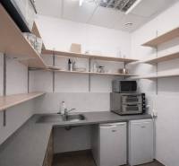 Kitchen corner with appliances and shelves in commercial premises.