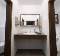 Bathroom with a sink, mirror, and sanitary equipment in commercial premises.