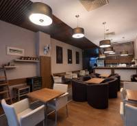 Interior of commercial spaces with comfortable chairs and tables, floor with wooden decor.