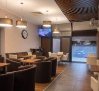 Interior of commercial spaces with wood-patterned flooring, chairs, and tables.