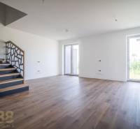 Interior of a family house with unusual railings, a wooden-patterned floor, and large windows.