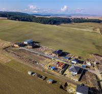 Houses under construction surrounded by fields and forests in Tvarožná.