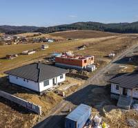 Family houses in Tvarožná with a view of the picturesque landscape and green hills.