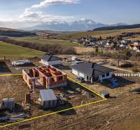 Construction of a family house in Tvarožná with a panorama of mountains behind the unfinished bungalow.