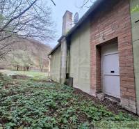 The exterior of the cottage in Chľaba with a green facade and a brick element.